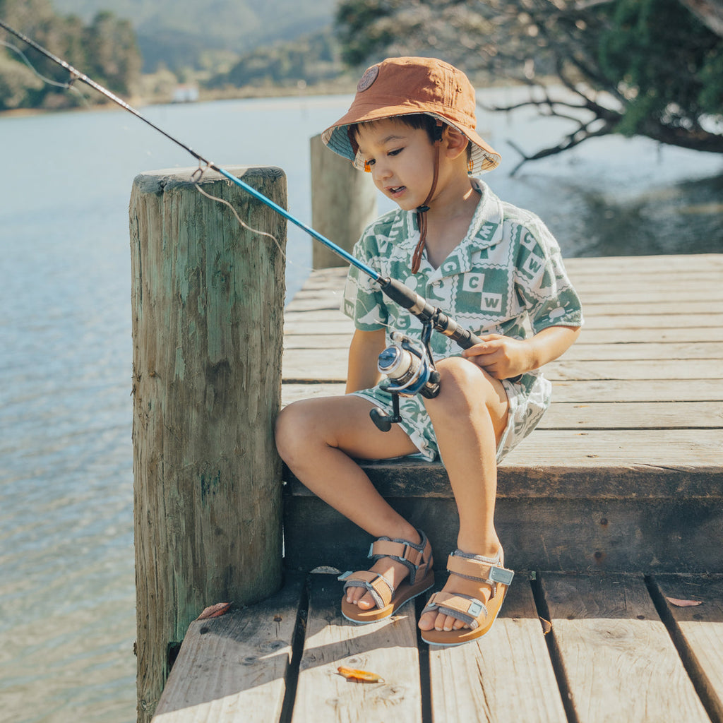 A child wearing the CRYWOLF resort set while fishing on a pier. 