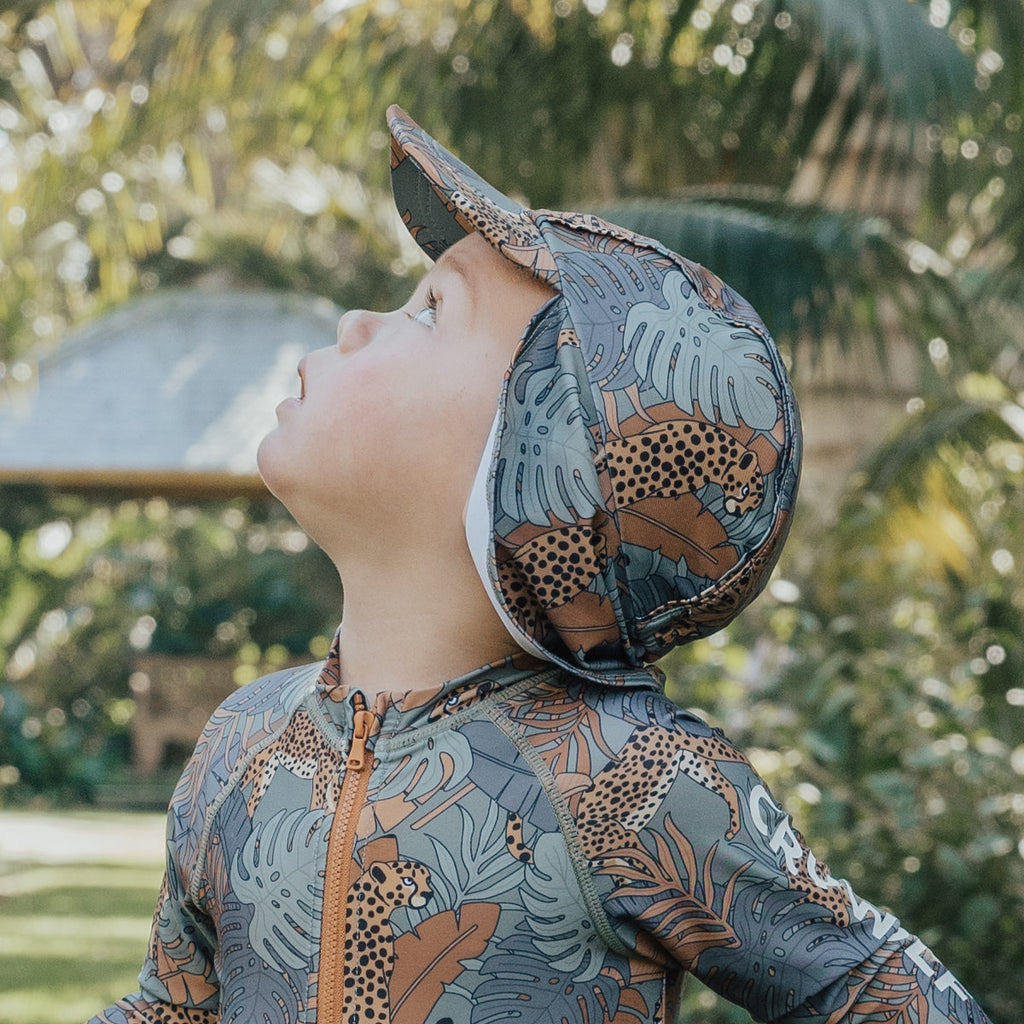 young child wearing a Cry Wolf children's Legionnaires hat and looking up at the sky.