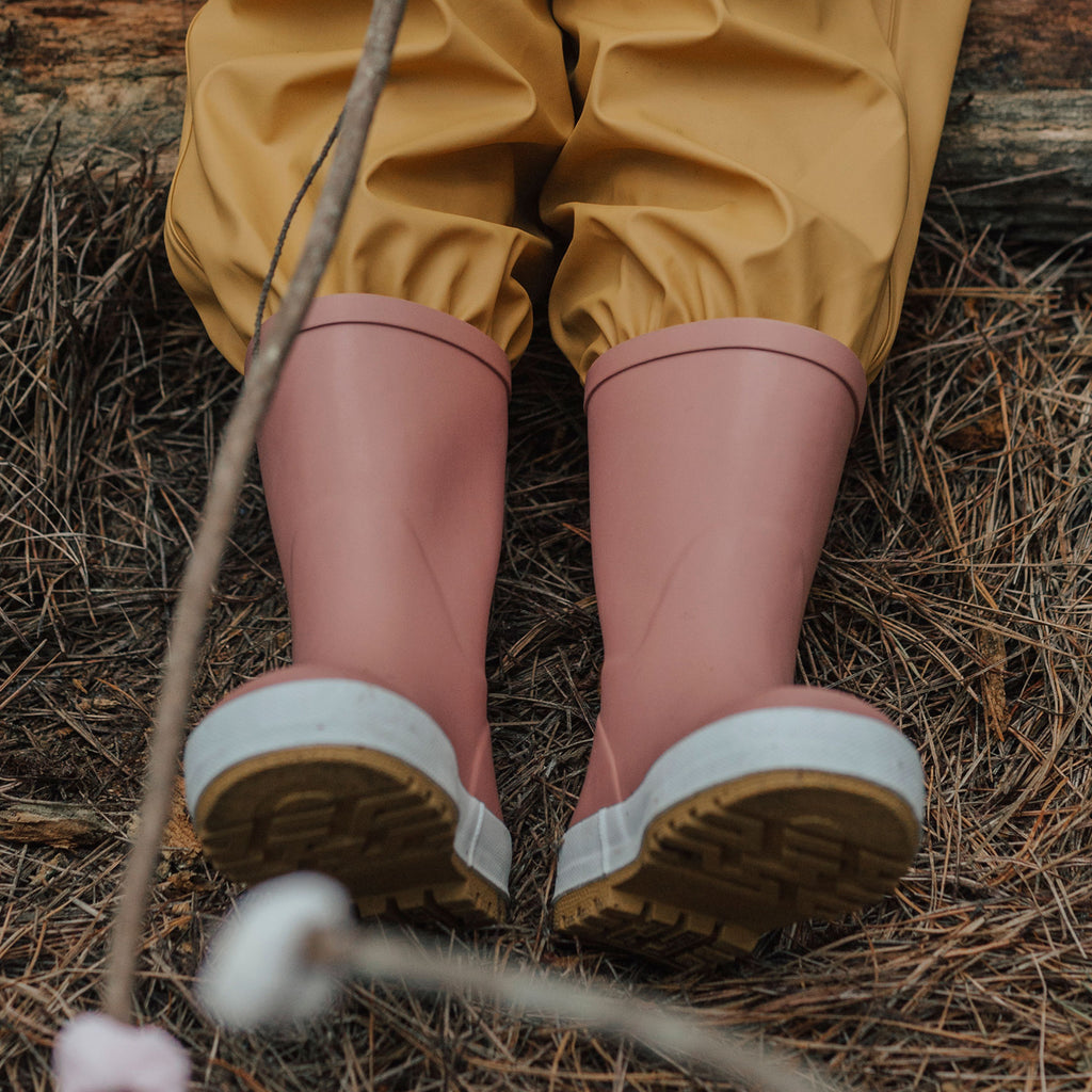 A Child Wearing Crywolf Rainboots Dusty Rose - Side View