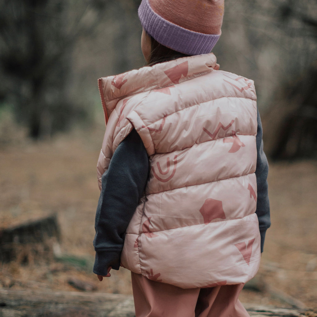 A Little Girl Outside Wearing Crywolf Reversible Vest Campfire Rose